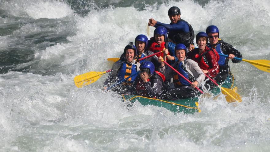 Grupo de personas en balsa haciendo descenso de río.