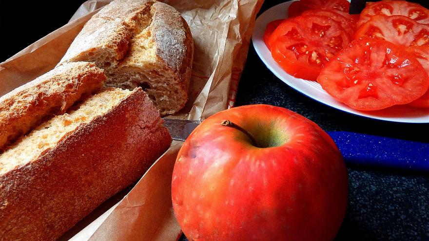 Dos rebanadas de pan de cereales con tomate