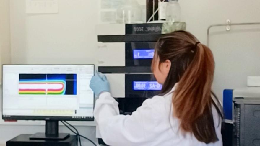 Mujer trabajando en el laboratorio de cromatografía del área de control de calidad