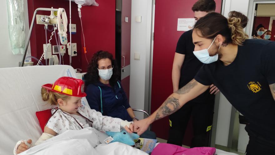 Bombero choca la mano con paciente pediátrica