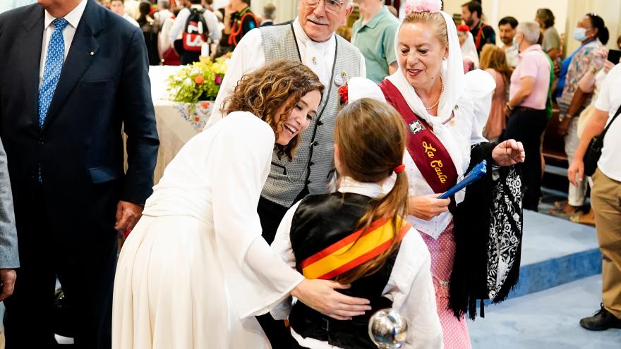 La presidenta Isabel Díaz Ayuso saluda a un niño en la misa