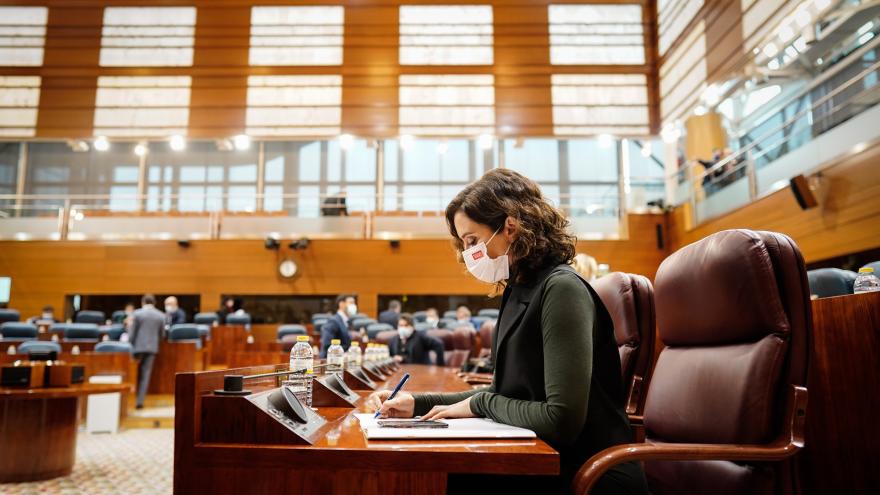 La presidenta escribiendo desde su escaño en la Asamblea regional