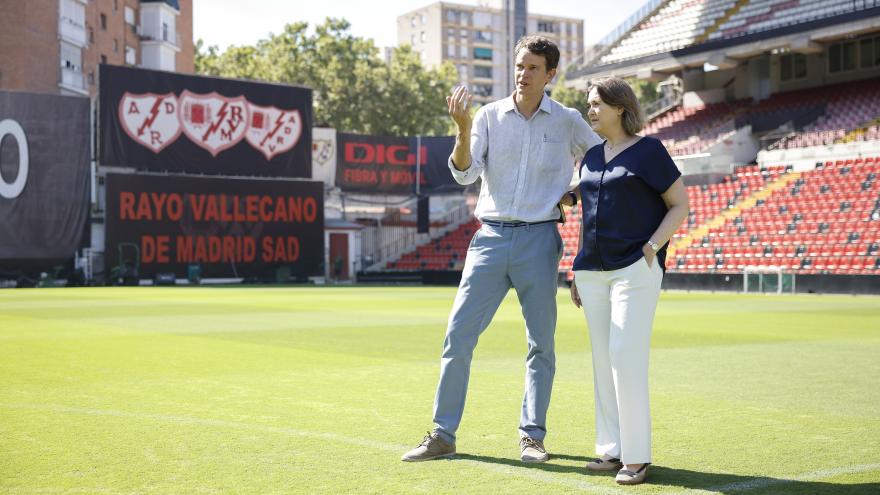 La consejera Marta Rivera escucha la explicación de una persona en el césped