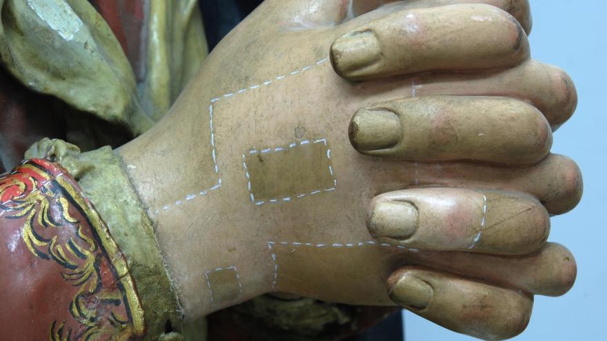Intervención en la policromía de la obra imagen de una escultura de madera detalle de las manos