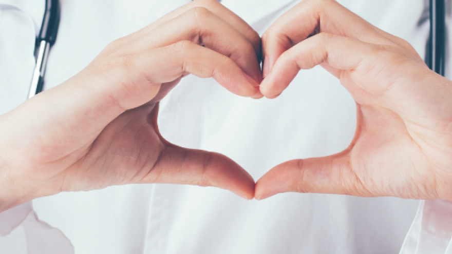 manos formando corazón con fondo médico bata blanca