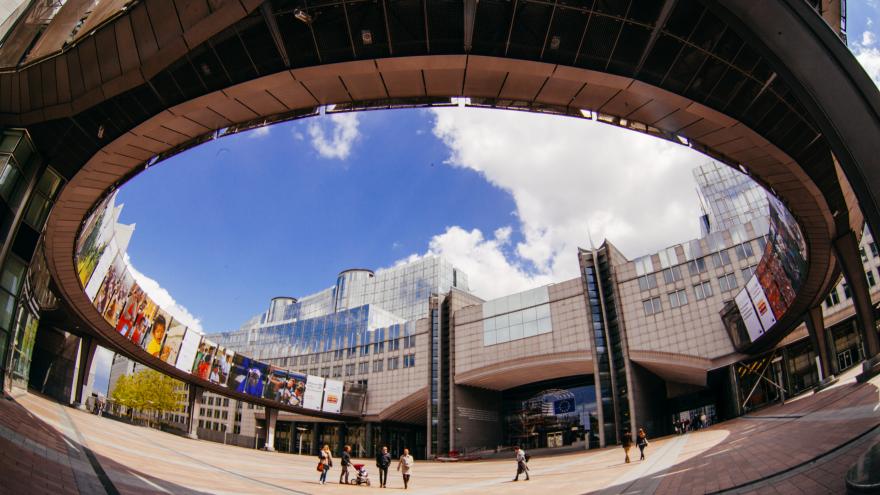 Exterior of the European Parliament building in Brussels, with a clear sky with clouds in the background