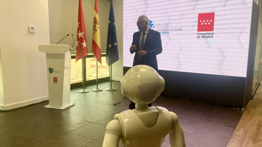 El consejero Carlos Izquierdo durante su intervención detrás de un robot