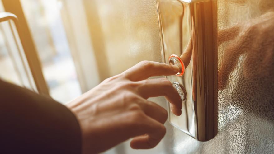 A person pushes an elevator button