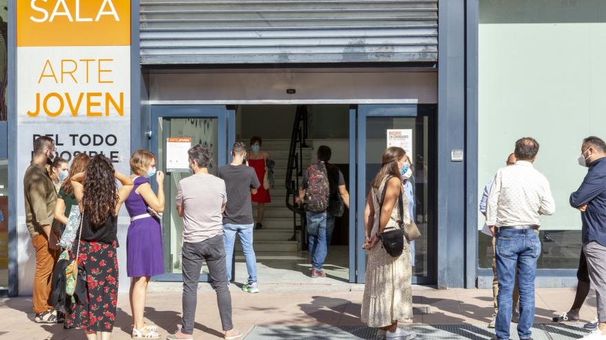 Grupo de personas en la puerta de una sala de exposiciones