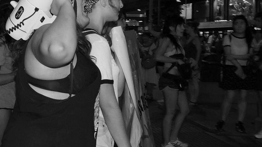 imagen en blanco y negro donde se ve a unas mujeres manifestándose, una de ellas con un megáfono