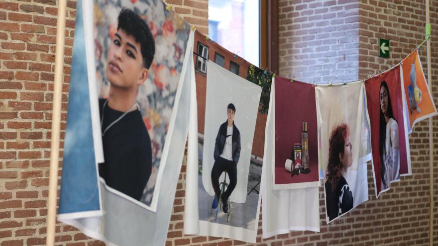 Photographs hanging on a rope between two posts