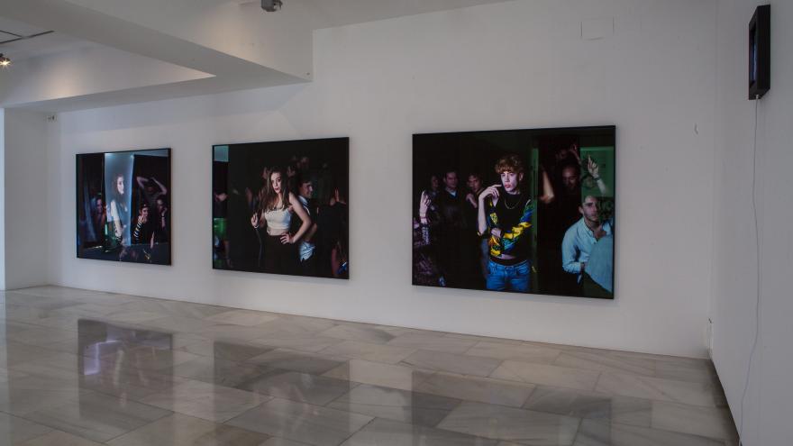 Three large format photographs hanging on a white wall