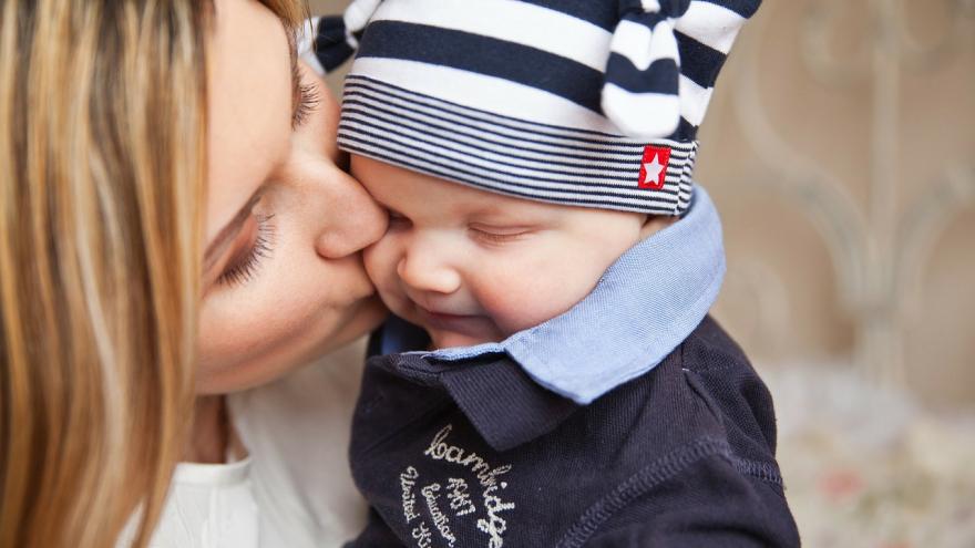 Madre con niño en los brazos dándole un beso