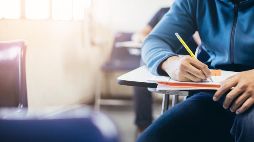 A college student writing with a pencil