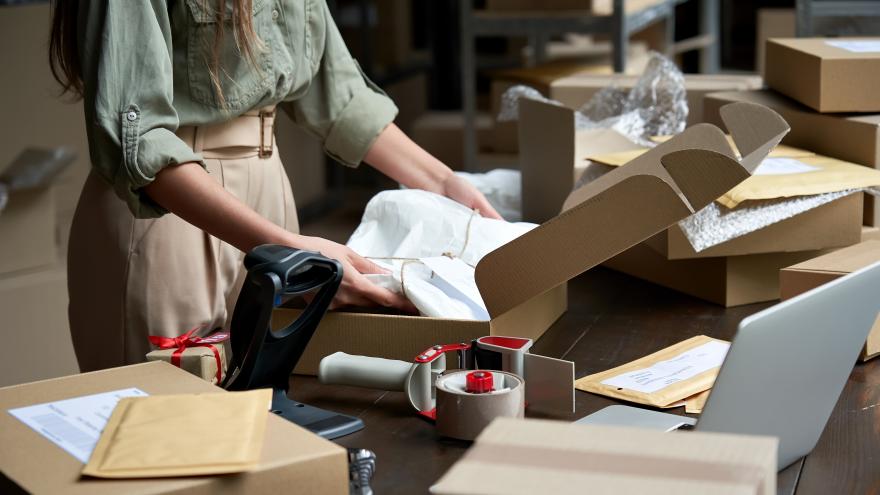 Una mujer guarda una ropa en una caja