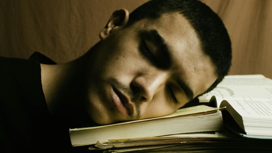 Imagen persona durmiendo sobre libros