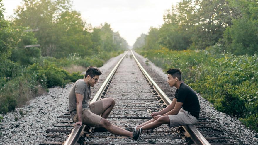 Chicos hablando en las vías del tren