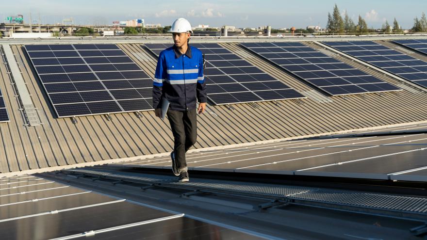 hombre sobre cubierta con placas solares