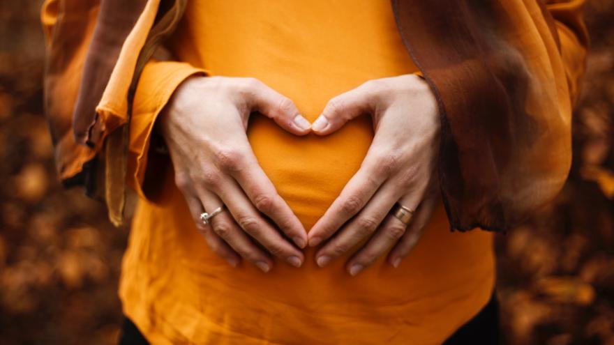 Imagen manos formando corazón sobre el abdomen