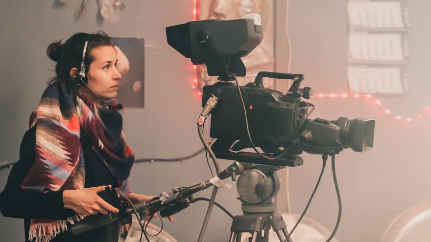 A woman handles a camera during a shoot