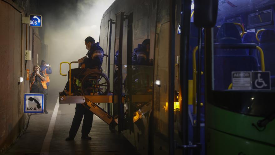 Una persona en silla de ruedas es sacada de un bus en el simulacro