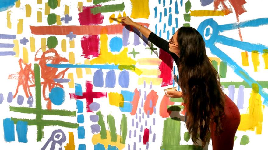 Fotografía de Claudia Sahuquillo pintando un mural