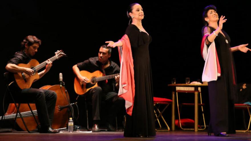 imagen de dos mujeres cantando e interpretando y detrás de ellas, sentados, dos guitarristas 