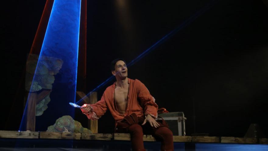 imagen en escena de un actor reflejando la luz de foco con un espejo de mano 