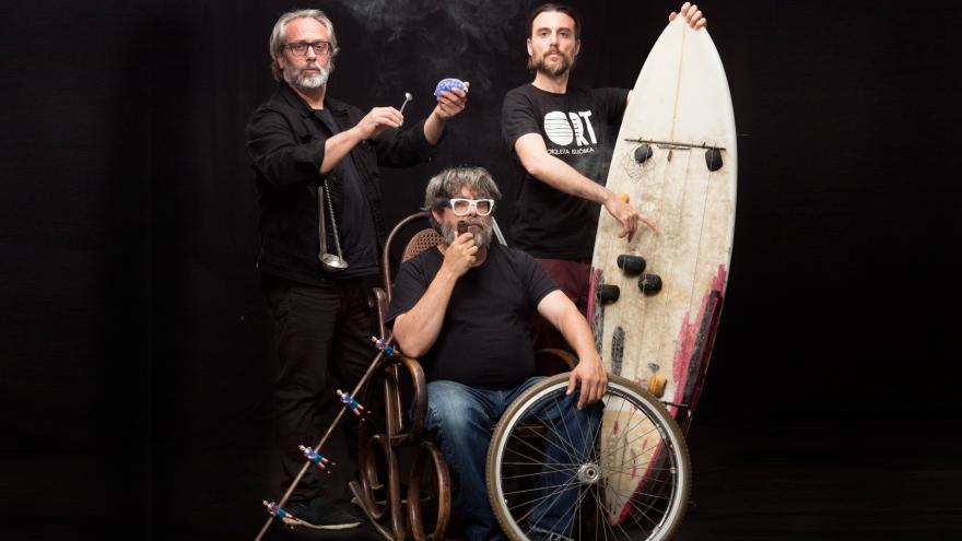 fotografía del trío con una mecedora, una rueda de bicicleta, una tabla de surf