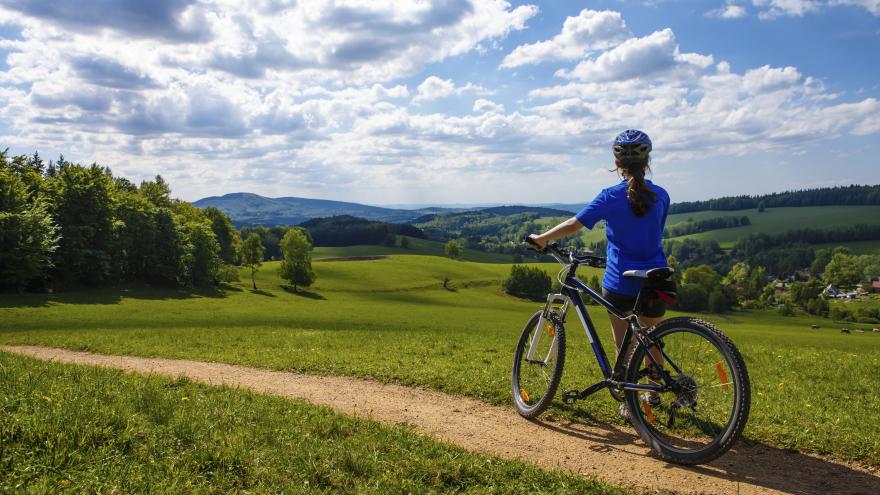 Cyclist on his back contemplating a green landscape