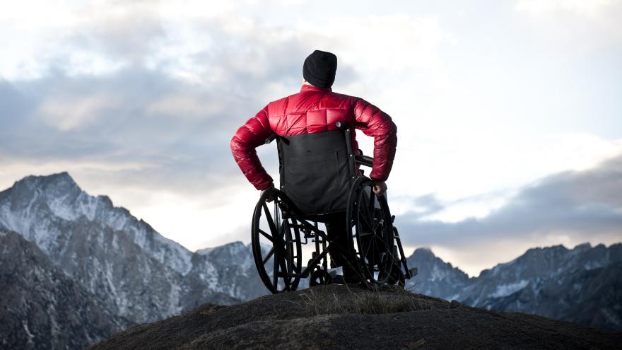 Hombre en silla de ruedas en un paisaje montañoso