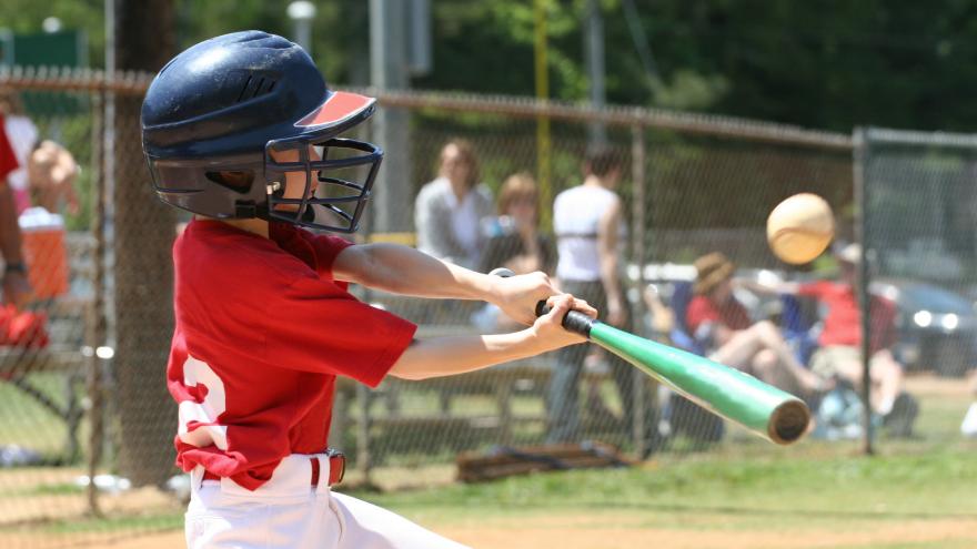 Niño bateando en un partido de béisbol