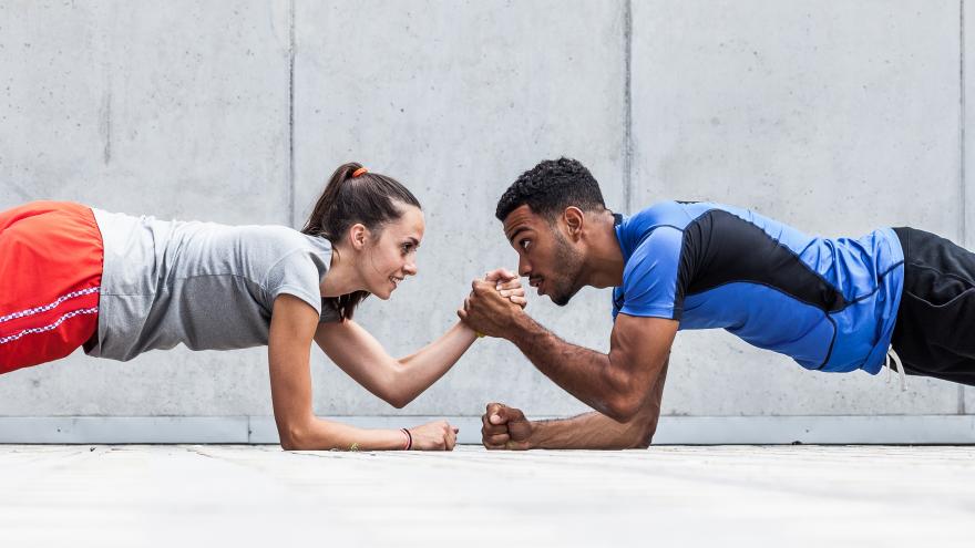 Hombre y mujer haciendo una plancha enfrentados