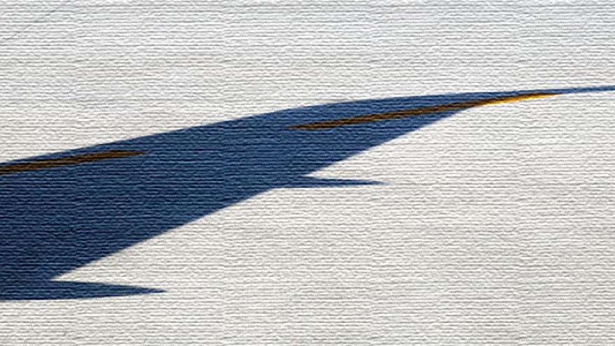 Sombra de un ala de un avión sobre la pista de despegue