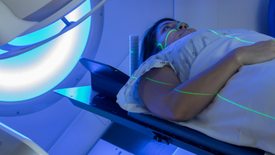 Paciente tumbado en camilla alineado recibiendo una sesión de radioterapia
