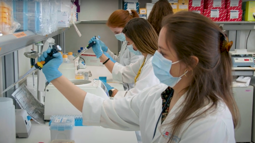 investigadoras sentadas trabajando con pipetas en un laboratorio