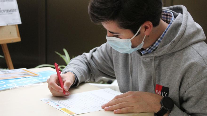 Joven sentado rellenando un formulario