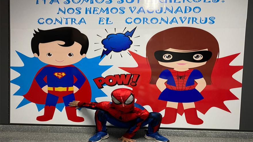 Niño disfrazado de Spiderman posa frente a photocall de superhéroes