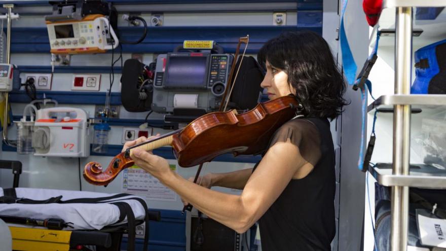Una violinista de la ORCAM interpreta una pieza musical en el interior de una UVI del SUMMA 112
