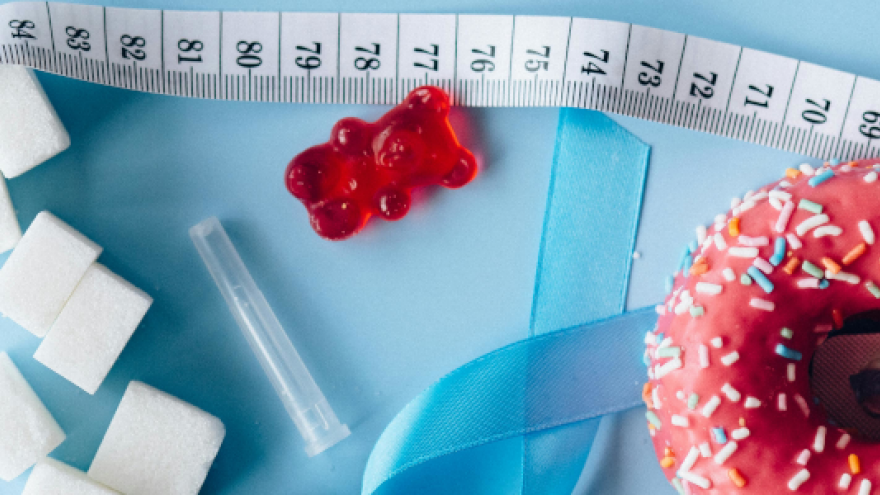 Imagen de un lazo azul, alimentos dulces y una cinta métrica