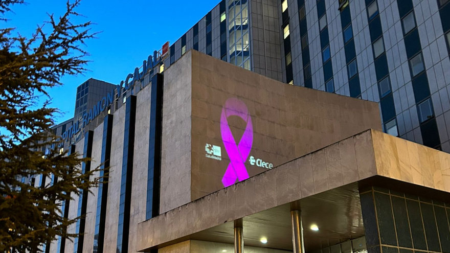 Imagen de la fachada principal del Hospital Universitario Ramón y Cajal con un lazo morado proyectado