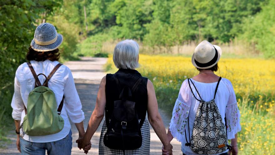 mujeres con mochila paseando por el campo