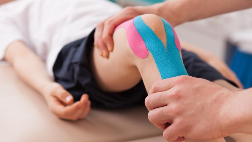 Fisioterapeuta tratando la rodilla de un paciente