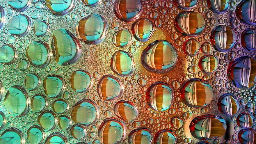 Gotas de agua sobre un cristal y fondo de distintos colores