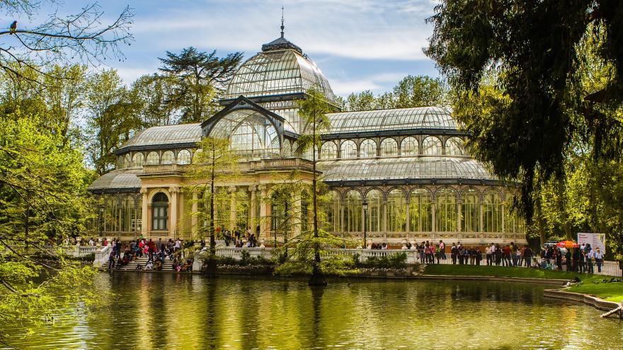 Vista del Palacio de Cristal del Parque del Retiro de Madrid con el estanque en primer plano en primavera