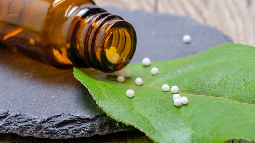 Frasco, pastillas sobre hoja de árbol