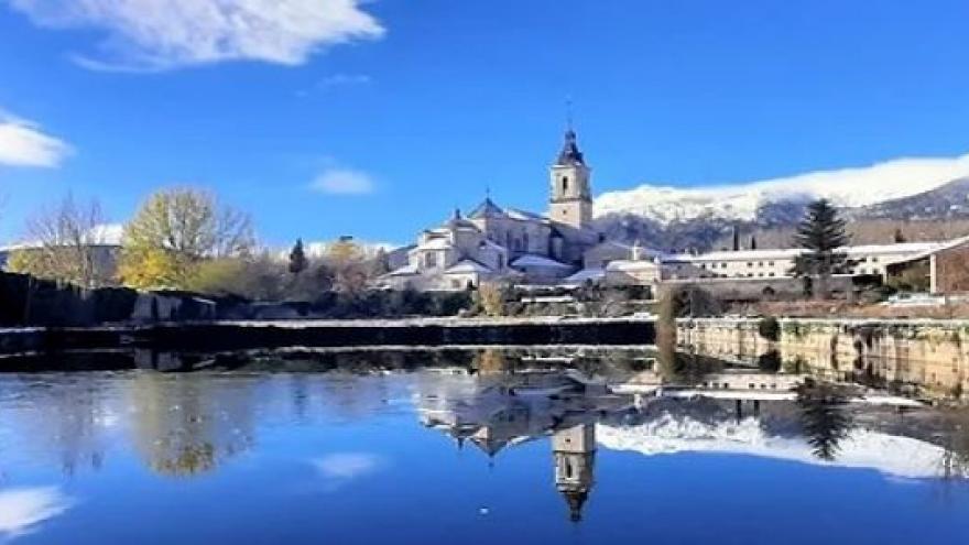 Vista nevada del monasterio reflejado en el agua