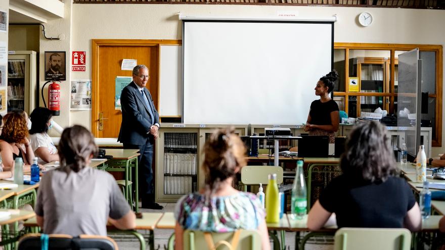 El consejero Enrique Ossorio mientras observa una clase con alumnos y su profesora