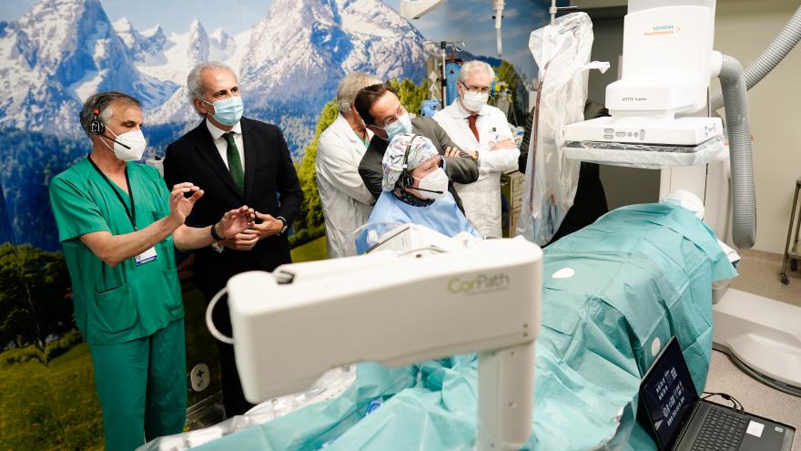 El consejero, acompañado de algunos sanitarios del hospital, observan el robot