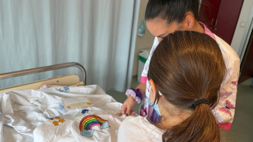 Niña ingresada de espaldas recibe pijama en el hospital